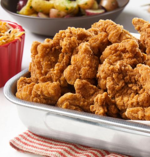 Morceaux de haut de cuisse de poulet panés désossés, entièrement cuits (assaisonnés)